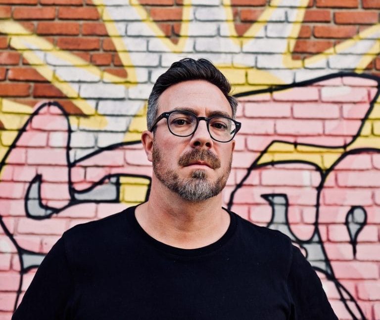Olivier Choinière devant un mur de brique
