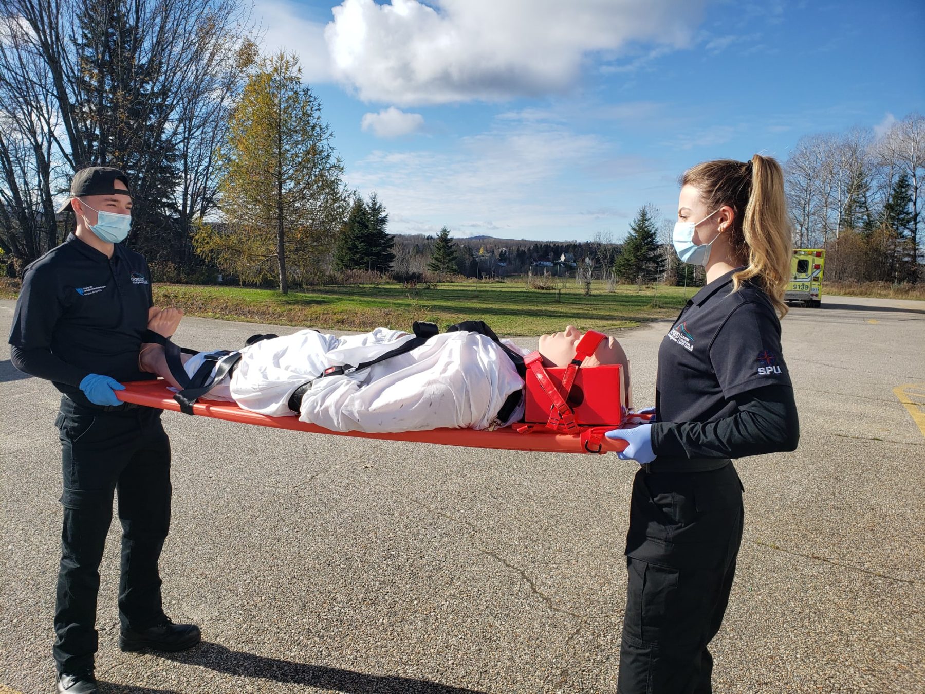 Deux étudiants avec un mannequin sur une civière