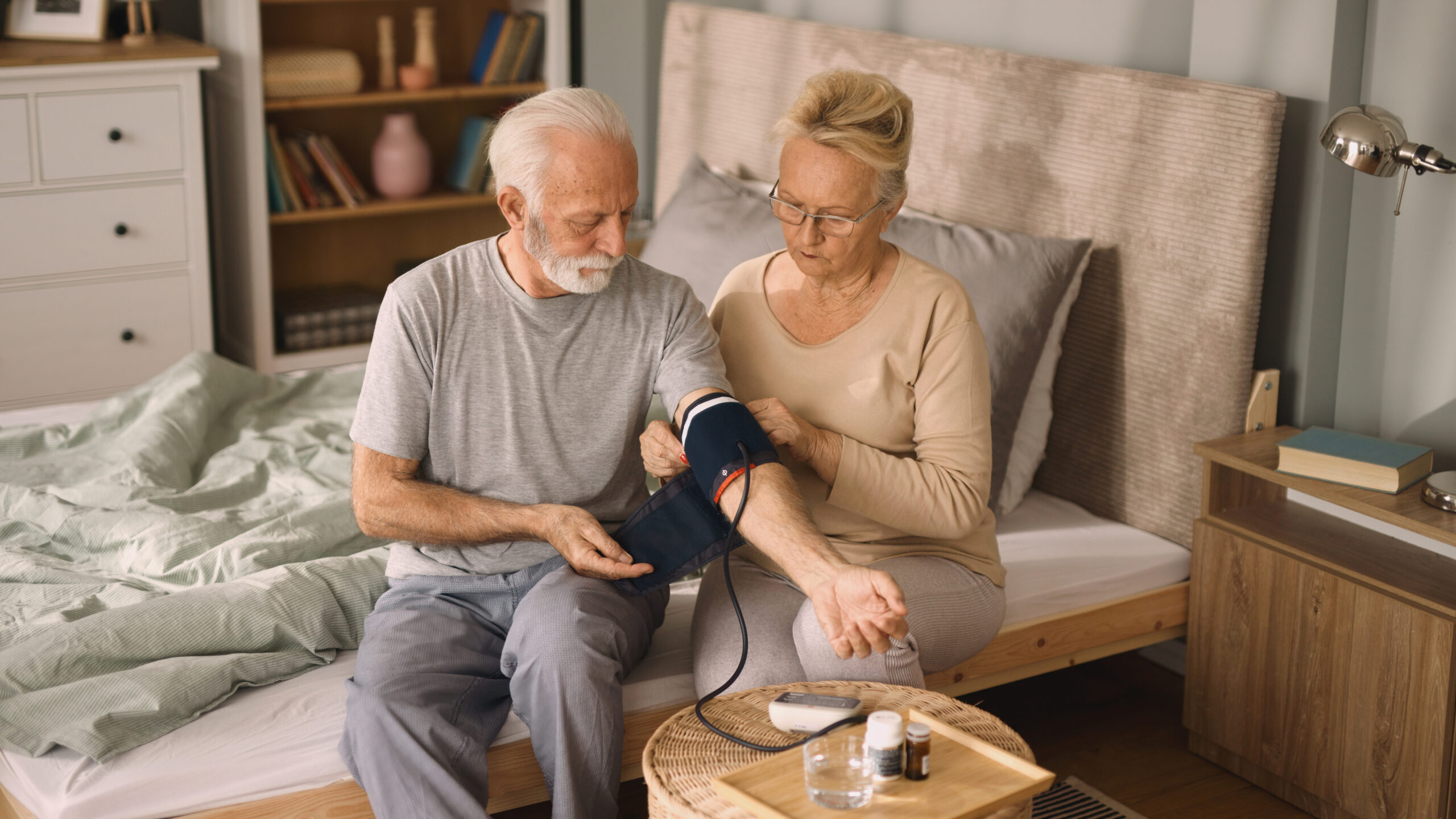 Senior couple measuring blood pressure at home